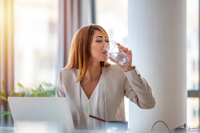 Office,Worker,Drinking,Water,Working,On,Line.,Young,Businesswoman,Drinking