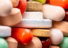 A close-up view of a variety of colorful pills and tablets stacked together