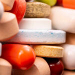 A close-up view of a variety of colorful pills and tablets stacked together