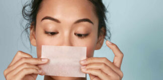 Woman holding a skincare strip in front of her face