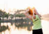 Gut Bacteria: The Secret Exercise Ally A woman stretching her arms by a lake during sunrise