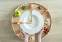 The One Ingredient That Slashes Cholesterol Hands holding a white plate surrounded by fresh vegetables and an egg