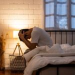 Stress Recovery Myths Shattered by New Findings A person sitting on a bed with their head in their hands, expressing distress