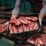 The Study Shaking Up Decades of Meat Myths A butcher holding a tray of fresh meat cuts