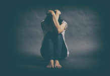 The Unexpected Antidote to Loneliness A person sitting on the floor with their arms wrapped around their knees, conveying a sense of distress