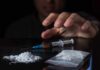 Stunning HIV-Meth Link Exposed A hand reaching for a syringe next to a pile of white powder