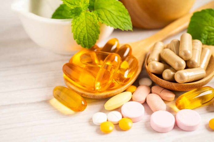 Assorted vitamins and supplements arranged with mint leaves