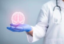 A medical professional holding a glowing digital brain illustration in their hand