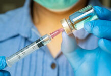 Healthcare professional preparing a syringe from a vial