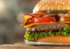 Close-up of a juicy hamburger with bacon, lettuce, tomato, and cheese