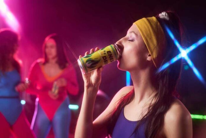 Woman in sportswear drinking an energy drink at a vibrant fitness party
