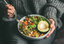 Diet Trap That Wrecks Your Blood Sugar A person holding a bowl of colorful salad with avocado and greens