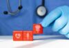 Premature and Early Menopause: Symptoms and Treatment A doctor's gloved hand placing red blocks with health symbols on a table