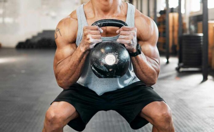 Bodybuilder,,Hands,And,Squat,For,Kettlebell,,Exercise,Or,Workout,For Athlete performing a kettlebell squat in a gym