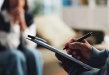 America’s Midlife Epidemic—Worse Than Europe? A therapist taking notes during a session with a client in the background