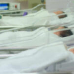 Newborn infants resting in hospital cribs in a nursery