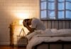 The Hidden Health Bill of Mind Replays A person sitting on a bed with their head in their hands, expressing distress