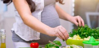 Person preparing a fresh salad with green vegetables in a kitchen