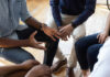 A group of people engaged in a discussion with hands gesturing expressively