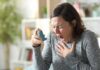 Allergy PTSD? Doctors Sound The Alarm Woman holding an inhaler during a coughing fit