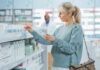 Woman shopping for medicine in a pharmacy aisle