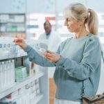 Woman shopping for medicine in a pharmacy aisle