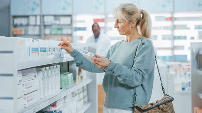 Woman shopping for medicine in a pharmacy aisle