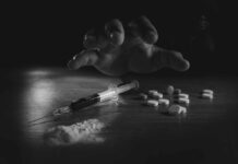 Basic Habits That Outsmart Substance Addiction A hand reaching for pills next to a syringe and powder on a table