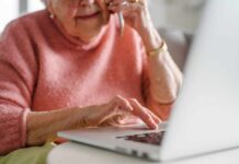Working From Home? This Easy Habit Will Improve Your Physical Health Elderly woman on a phone call while using a laptop