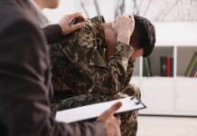 Stop Saying This To Depressed Friends Soldier in camouflage sits with head in hands during counseling session