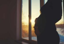 Second Baby, Different Brain Wiring Silhouette of a pregnant woman standing by a window at sunset