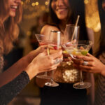 Group of friends toasting with cocktails at a party