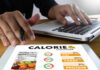 High-sugar diets impact on your brain health Person using a calorie counter app on a tablet while working on a laptop
