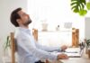 The Science of Silence: How It Rewires Your Brain Man relaxing at desk with eyes closed beside laptop