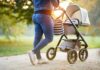 Person pushing a baby stroller on a park path