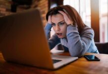 How Can We Protect Mental Health in a Remote Work Era? Woman holding head while looking at laptop