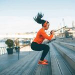 Woman exercising on outdoor steps by a riverside