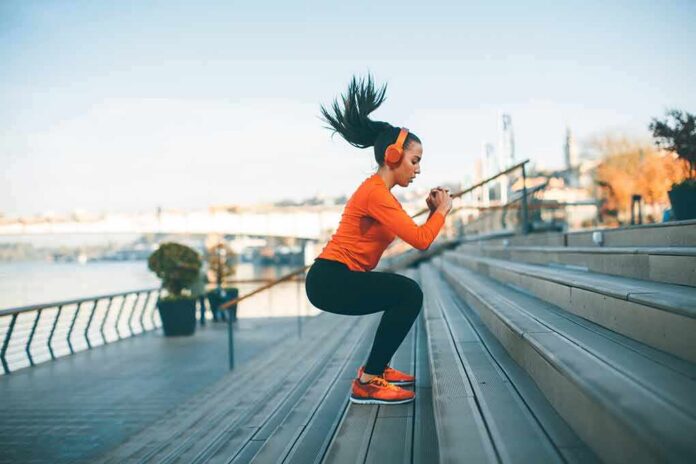 shutterstock_1080117269 Woman exercising on outdoor steps by a riverside
