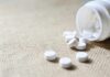 Heart Pill That Slows Your Brain Fade White tablets spilling from a plastic bottle