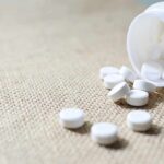 White tablets spilling from a plastic bottle