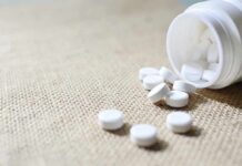White tablets spilling from a plastic bottle