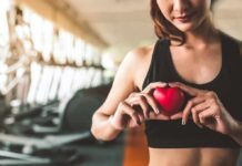 How To Workout For Healthy Arteries Woman in sportswear holding a red heart-shaped object at the gym