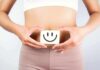 torso of person holding smiley card over stomach
