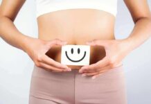 torso of person holding smiley card over stomach