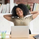 Woman relaxing at desk with laptop