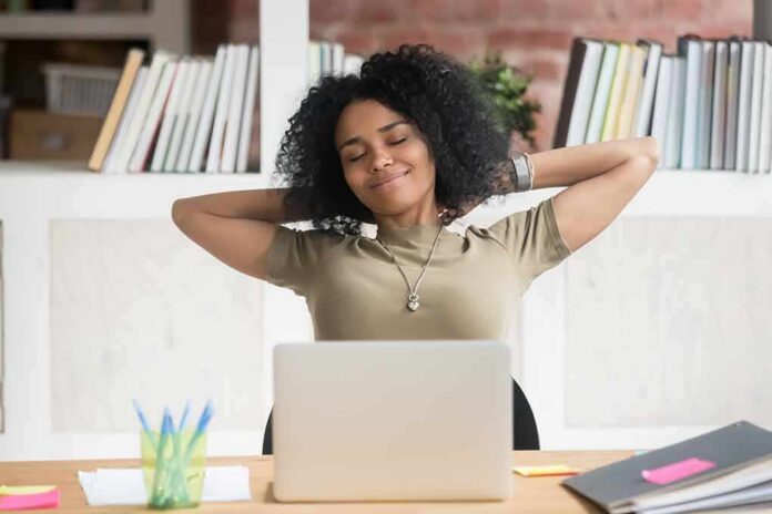 Woman relaxing at desk with laptop