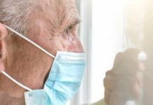 Midday Sun: Big Gains, Bigger Risks Older man wearing a surgical mask looking out a window