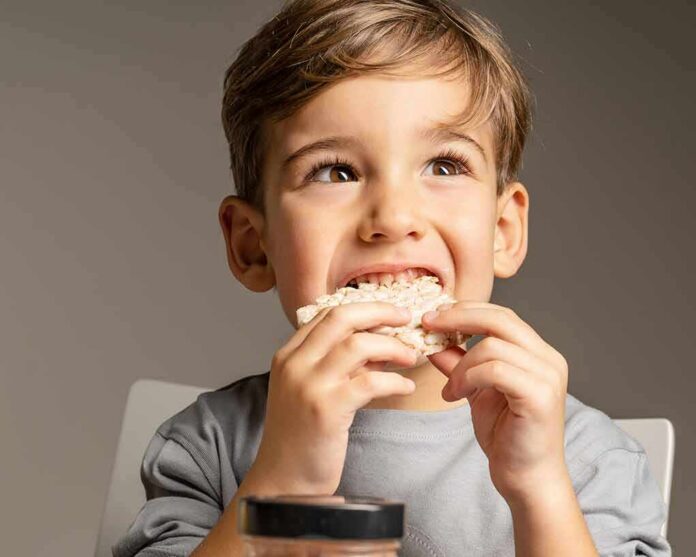 shutterstock_1912696918 child eating a rice cake