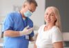 Smiling woman receiving a vaccination from a healthcare worker