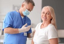 Blood Clues That Flag Alzheimer’s Years Early Smiling woman receiving a vaccination from a healthcare worker